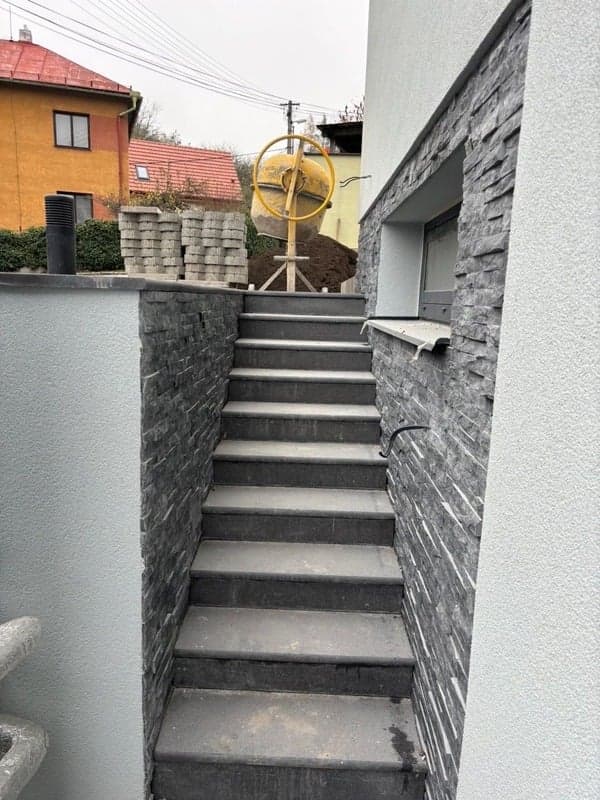 Dokončené betonové venkovní schodiště s kamenným obkladem stěn